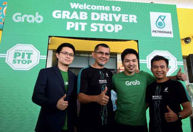  Syed Zainal (dua kiri) bergambar bersama (dari kiri) Sean dan Aadrin selepas melancarkan ‘Grab Driver Pit Stop’ di stesen Petronas Mutiara Damansara, Kuala Lumpur, semalam. — Gambar Bernama