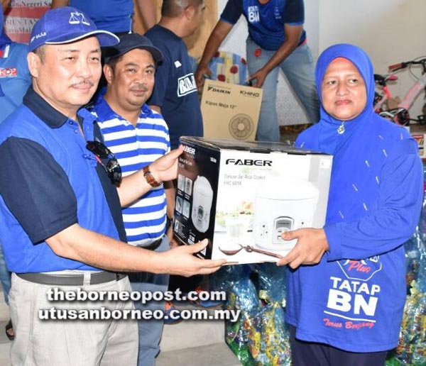 HAJIJI menyampaikan barang keperluan dapur kepada seorang suri rumah, diperhatikan oleh Bakri.