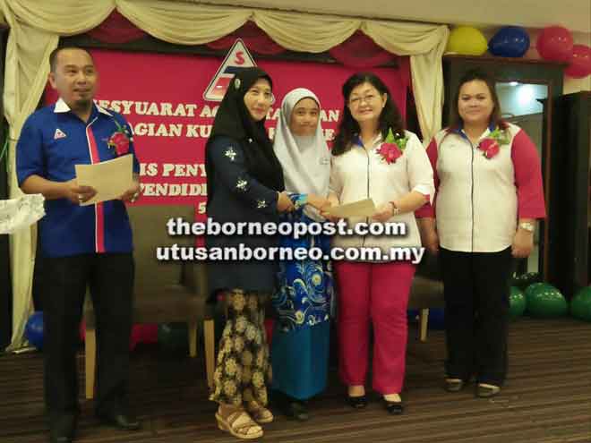  Fu (dua kanan) menyampaikan insentif pendidikan STU kepada para pelajar semasa Mesyuarat Agung Tahunan STU Bahagian Kuching Kali Ke-15 dan majlis penyampaian insentif pendidikan di sebuah hotel terkemuka di Kuching, baru-baru ini. Turut kelihatan, Abdul Aziz (kiri).