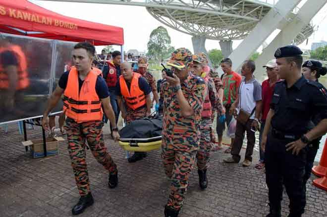  Mayat remaja terbabit diusung ke tebingan untuk pemeriksaan sebelum disahkan meninggal oleh pasukan paramedik. — Gambar ihsan Rosli Zainal Abidin