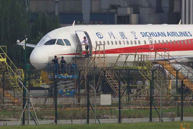  Pekerja memeriksa pesawat Sichuan Airlines yang membuat pendaratan kecemasan selepas cermin depan kokpit tercabut, di lapangan terbang di Chengdu, wilayah Sichuan, China kelmarin. — Gambar Reuters