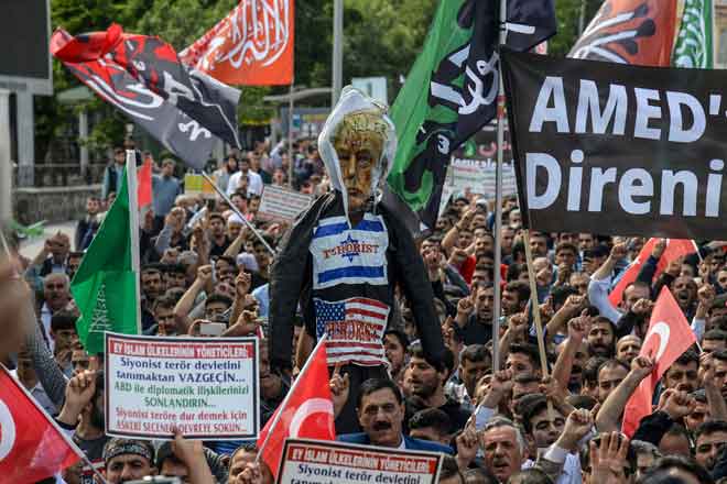  Penunjuk perasaan memegang patung dengan gambar Trump sambil melaungkan slogan di Diyarbakir kelmarin semasa perarakan besar-besaran untuk mengutuk pertumpahan darah di sempadan Gaza dan pembukaan kedutaan AS di Baitulmuqaddis ketika konsul jeneral Israel diarahkan meninggalkan negara itu buat sementara waktu. — Gambar AFP