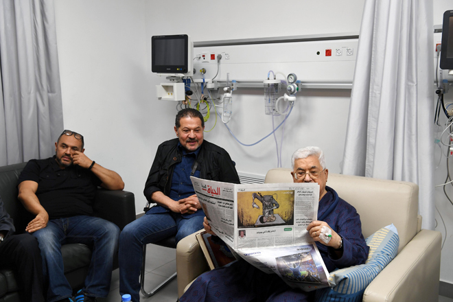  Gambar serahan Pejabat Presiden Palestin (PPO) menunjukkan Abbas membaca surat khabar di hospital di Ramallah, di wilayah Tebing Barat, kelmarin. — Gambar Reuters