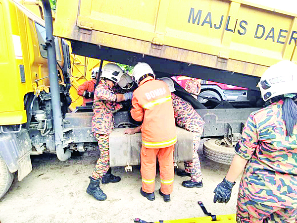 ANGGOTA bomba melakukan operasi mengeluarkan mangsa tersepit di bawah trak lori.