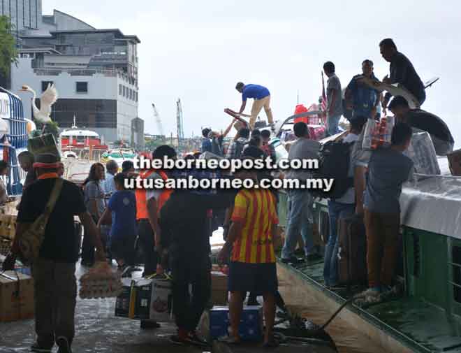  Penumpang bot ekspres sibuk menyimpan barang mereka di atas bot ekspres.