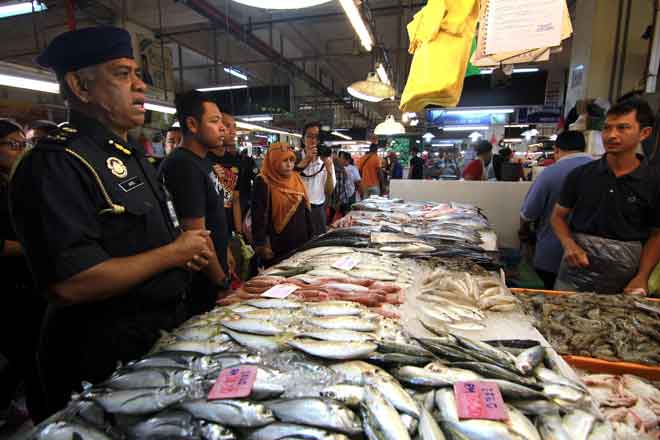  Aris (kiri) meninjau harga ikan ketika menjalankan pemeriksaan di Pasar Awam Larkin, Johor Bahru semalam. — Gambar Bernama