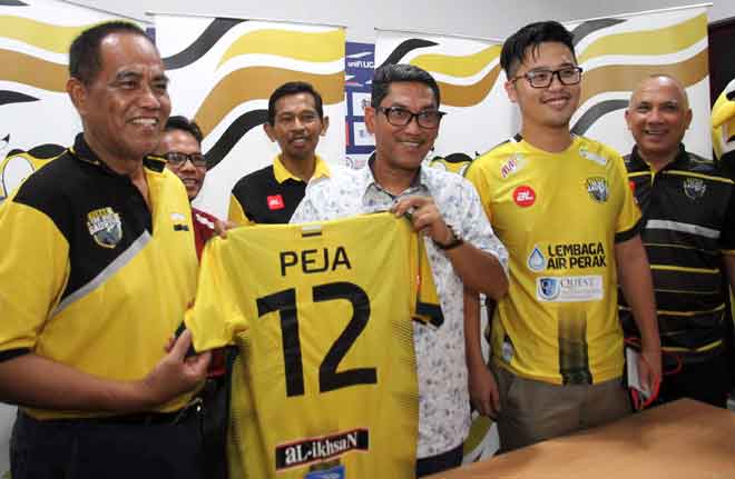  Ahmad Faizal (tengah) menerima jersi bola Perak daripada Abdul Puhat sambil disaksikan Lee (dua kanan) dan yang lain ketika sidang media pada perlawanan bola Liga Super Perak bertemu PKNP FC di Stadium Perak malam kelmarin. — Gambar Bernama 