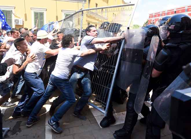  Penyokong pembangkang bertempur dengan polis perusuh semasa perhimpunan menyeru bagi peletakan jawatan menteri dalam negeri Fatmir Xhafaj apabila adik lelaki beliau terbabit dalam penyeludupan dadah di Tirana kelmarin. — Gambar AFP