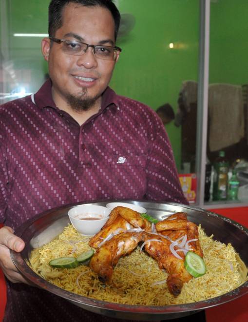  Zulhasnan menunjukkan antara menu Nasi Arab Asli berasaskan Ayam Golek yang disediakan untuk para pelanggan yang datang untuk menjamu selera di Gong Nering Besut sempena bulan Ramadan ini. — Gambar Bernama