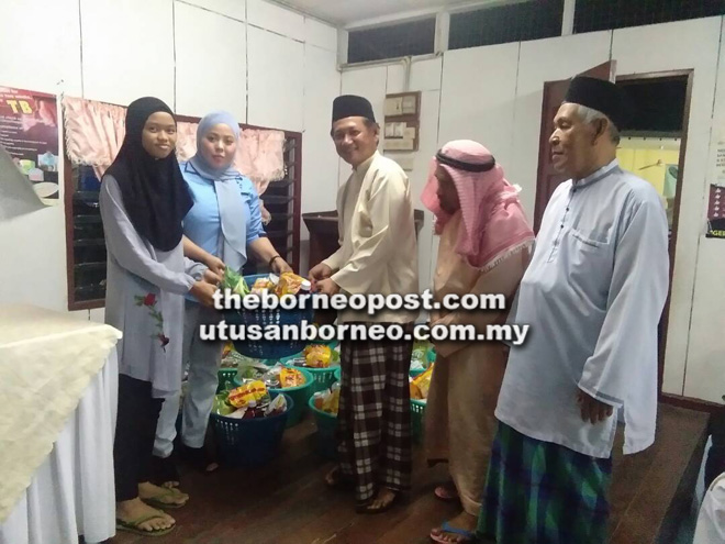  Awang Husaini (tiga kanan) menyampaikan raga makanan sumbangan Yayasan Afat Rahman kepada salah seorang penerima.