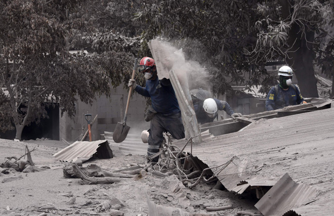  Penyelamat menggeledah rumah ditutupi abu untuk mencari mangsa terselamat selepas gunung berapi Fuego meletus di kampung San Miguel Los Lotes,                    di bahagian Escuintla, kira-kira 35 kilometer barat daya Guatemala kelmarin. — Gambar AFP