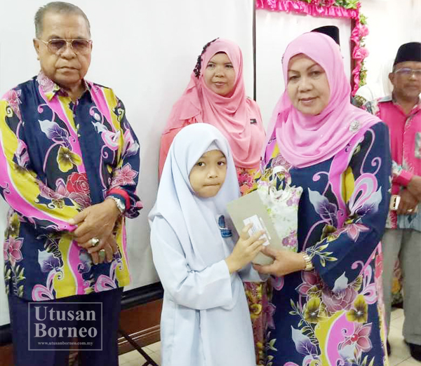 SALAH seorang anak yatim menerima sumbangan daripada Dayang (kanan) sambil diperhatikan Abdul Rahman dan Murni.