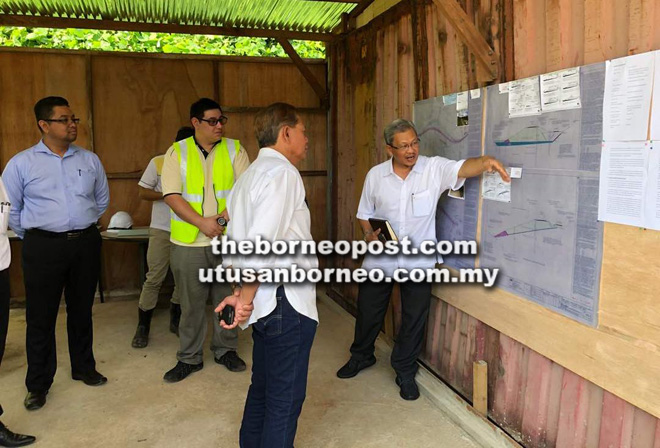  Amrullah menyampaikan taklimat kepada Muis dan rombongan mengenai keadaan cerun serta kerja yang dijalankan. Turut kelihatan, Faizal (kiri).