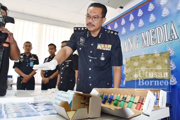 HAMZAH menunjukkan barang rampasan berkaitan kes itu.