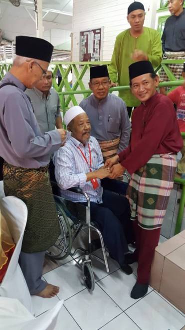 MOHD Dahali (dua kanan) bersama Awang Husaini menyampaikan bantuan kepada seorang warga emas OKU. 3. AWANG Husaini dan Mohd. Dahali menyampaikan bantuan kepada penerima di majlis itu.