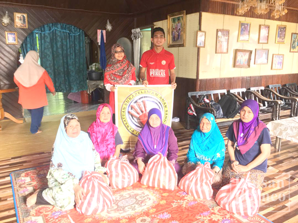 MOHD Johari (belakang, kanan) menyampaikan sumbangan kepada keluarga kurang berkemampuan sempena bulan Ramadan.