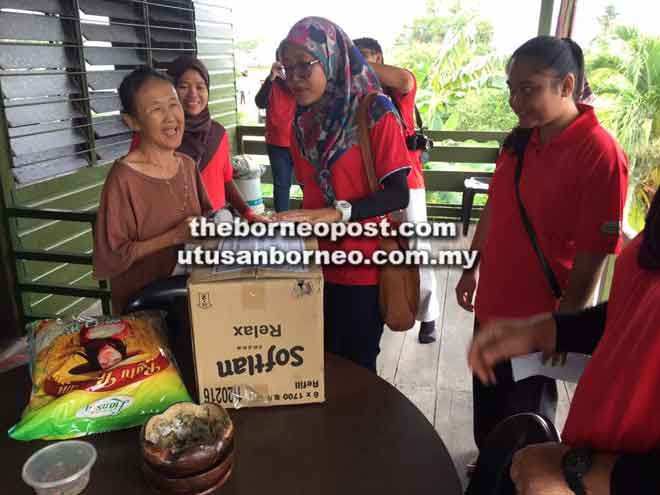  Syuhaira (tengah) mewakili PPKS/ICATS Miri menyampaikan sumbangan kepada salah seorang penerima Program Tautan Kasih Syawal.