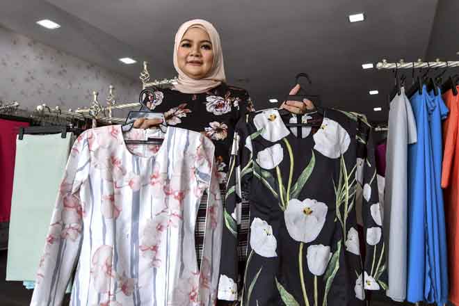  Alia memastikan material kain yang dijual di butiknya jenis sejuk, selesa dipakai dan tidak rasa melekit atau gatal pada badan bersesuaian dengan konsep ‘minimalis’, trend baju raya pada tahun ini. — Gambar Bernama