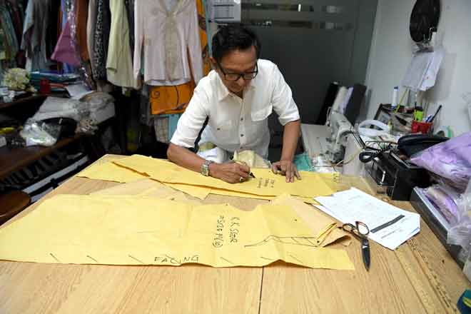  Salikin membuat pola untuk rekaan bajunya ketika temu bual eksklusif bersama wartawan Bernama di Butik Mahligai Salikin Sidek baru-baru ini. — Gambar Bernama