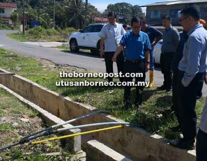  Lee (dua kiri) ketika meninjau pembinaan sistem parit konkrit di Kampung Pujut Tanjong Batu di Miri, semalam, sambil diiringi Ir. Chai (kiri) serta Morshidi (kanan) dan yang lainnya.