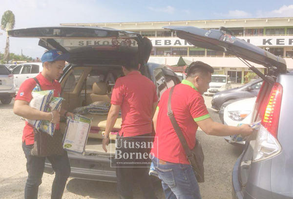 AHLI- ahli Mas mengangkat sumbangan beras untuk diserahkan kepada pihak sekolah.