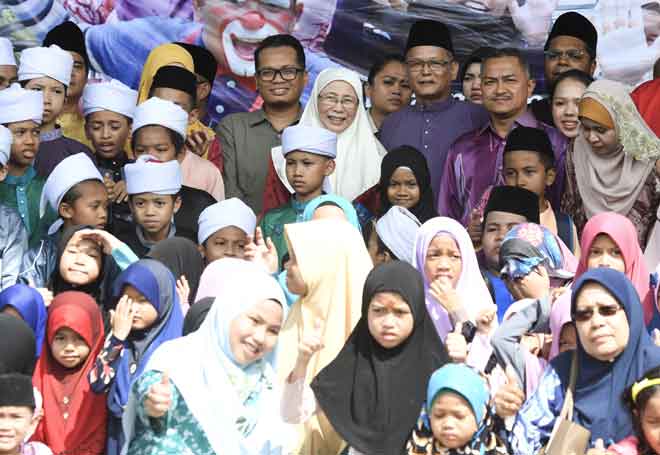  Wan Azizah (tengah) bergambar bersama anak-anak yatim pada Majlis Jamuan Tertutup Eksklusif Sambutan Aidilfitri Bersama 2,000 Anak Yatim Asnaf di Stadium Mini Setawangsa, semalam. — Gambar Bernama