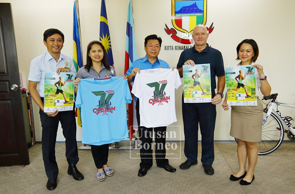 YEO (tengah) bersama Rick (dua kanan) menunjukkan baju Larian Amal 7K selepas kunjungan hormat itu.