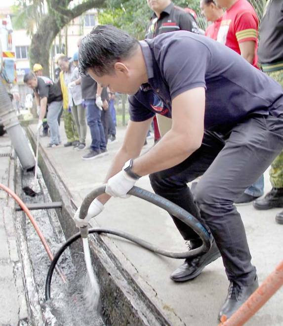 MOHD Azis Jamman turut serta membersihkan longkang Pasar Pekan Manggatal pada Program Turun Padang CSR hari ini.