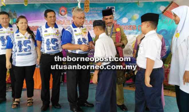  Mahmud (empat kiri) menyampaikan duit raya kepada murid-murid yatim dan kurang berkemampuan.