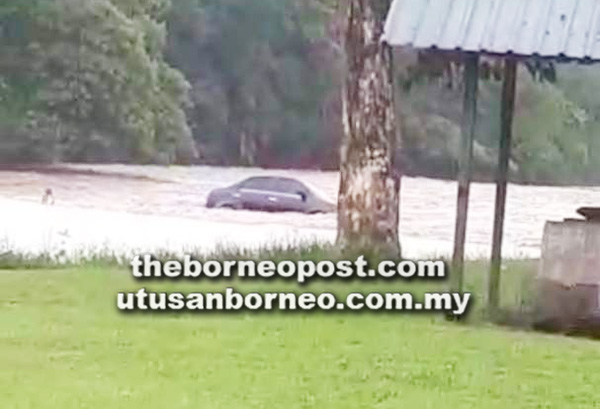 KERETA yang ditularkan hanyut di Sungai Babagon, Penampang.