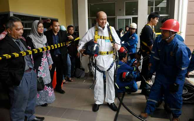  Lee memakai pakaian dan alat keselamatan ketika demonstrasi menggunakan peralatan perlindungan diri untuk operasi menyelamat di ruang terkurung atau sempit pada Program Keselamatan dan Kesihatan Pekerjaan untuk Pengamal Media di Ibu Pejabat NIOSH Wilayah Selatan, Taman Teknologi Johor semalam. — Gambar Bernama