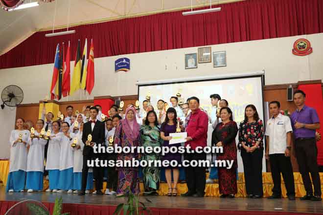  Kong (lima kanan) menyampaikan trofi kepada SMK Kidurong yang muncul johan kategori sekolah menengah Pertandingan Bicara Berirama Peringkat Negeri Sarawak 2018.