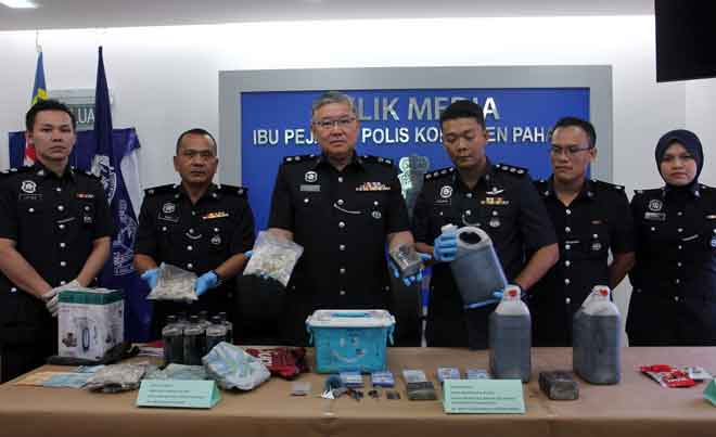 Lam (tiga kiri) bersama pegawainya menunjukkan pelbagai jenis dadah, cecair dipercayai ubat batuk serta barang kes lain yang dirampas ketika mengadakan sidang media di Ibu Pejabat Polis Kontinjen Pahang, Kuantan, semalam. — Gambar Bernama