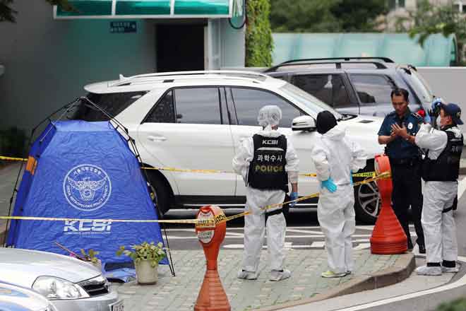  Pegawai polis berdiri di sebelah khemah yang didirikan di mana Roh (sisipan) ditemui mati berhampiran pintu pagar bangunan apartmen di tengah Seoul semalam. — Gambar AFP/Yonhap