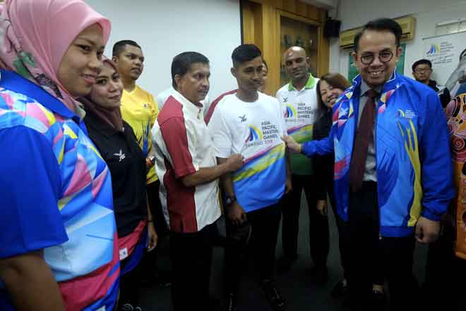  Sim (kanan) menunjukkan baju rasmi yang akan digunapakai semasa temasya sukan Asian Pacific Masters Games 2018 (APMG 2018) pada majlis Pelancaran APMG 2018 di Wisma UFL, Kuala Lumpur semalam. Turut hadir Pengarah Urusan Universal Fitness & Leisure Sdn Bhd Datuk Radha Krishnan (empat, kiri). — Gambar Bernama