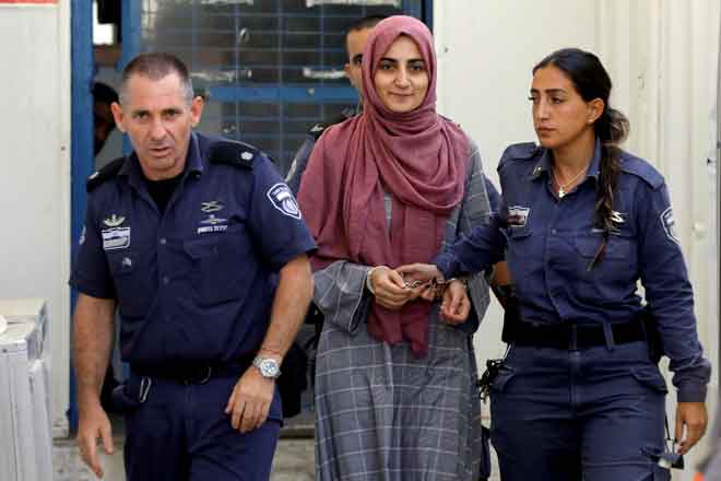  Gambar fail 8 Julai menunjukkan Ozkan (tengah) diiringi oleh dua pegawai penjara  ke mahkamah tentera Israel. — Gambar Reuters