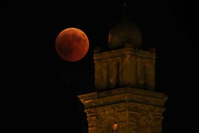  Gambar menunjukkan bulan penuh semasa gerhana ‘bulan darah’ berdekatan sebuah gereja Venzolasca di Pulau Corsica Mediterranean Perancis, semalam. — Gambar AFP