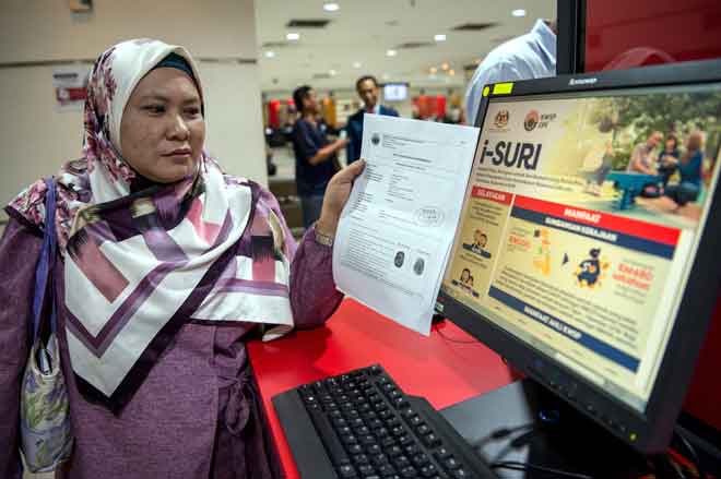  Seorang wanita Jamaliah Ismail menunjukkan borang pendaftaran yang telah diluluskan selepas membuat pendaftaran Caruman Sukarela Insentif Suri (i-Suri) di Ibu Pejabat KWSP, Jalan Raja Laut di Kuala Lumpur, semalam. — Gambar Bernama