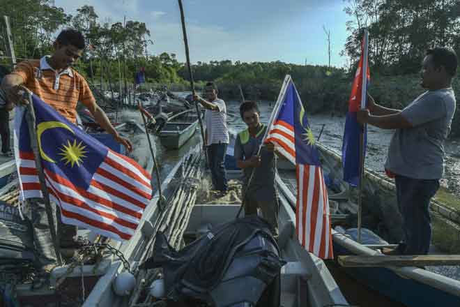  Sebahagian nelayan Orang Asli Kampung Baru, Kuala Benut memasang Jalur Gemilang pada bot masing-masing. — Gambar Bernama