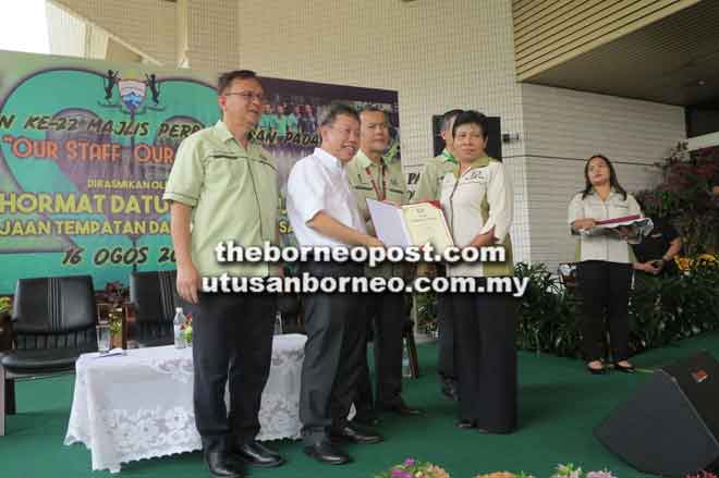  Dr Sim menyerahkan sijil Anugerah Perkhidmatan Cemerlang kepada Noni Rao. Turut kelihatan Lo (kanan) dan Ahmad (tiga kanan).