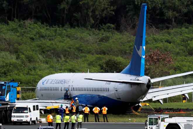  Beberapa pekerja cuba mengalihkan Xiamen Air Boeing 737-800 selepas tergelincir dari landasan di Lapangan Terbang Antarabangsa Ninoy Aquino di Paranaque, Metro Manila di Filipina kelmarin. — Gambar Reuters