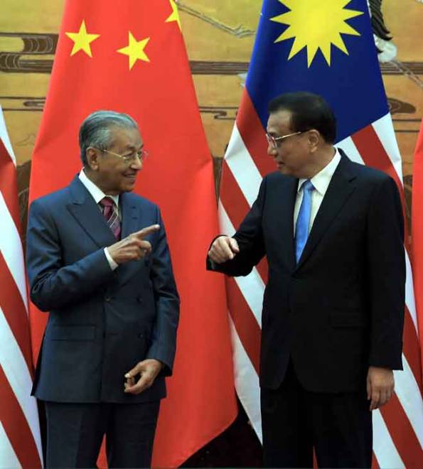  Tun Dr Mahathir (kiri) berbual dengan                      Li pada Majlis Sambutan Rasmi di Great Hall of The People                         di Beijing semalam. — Gambar Bernama