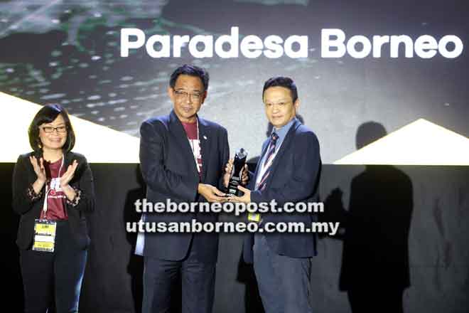  Abdul Karim nyuaka perais ngagai pengari Paradesa Borneo ti menang Anak Sarawak Business Events Award - Product and Service of Excellence, seraya diperatika (kiba) Amelia. — Gambar Chimon Upon  