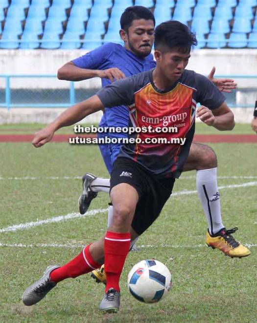  Penyerang SSN Sarawak, Mohd Faris cuba dihalang pemain UiTM Sarawak FC, Muhammad Adib (jersi biru) pada aksi K-League 2018 di Stadium Sarawak, Petra Jaya semalam.