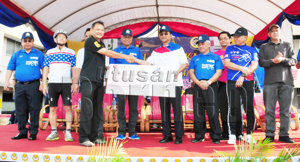 ZULKIFLI (empat kiri) menyaksikan Jaujan (empat kanan) menyerahkan cek replika kepada wakil Rumah Warga Tua Air Panas Tawau hari ini.