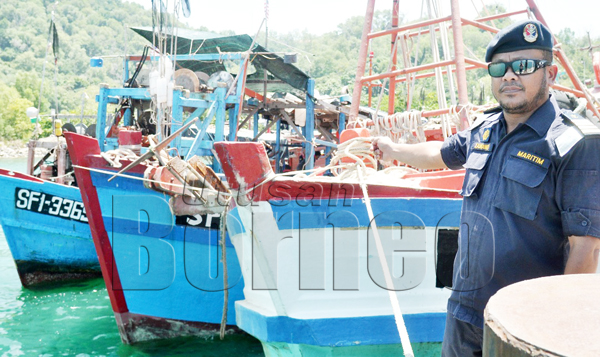 ZAWAWI menunjukkan tiga bot nelayan yang dirampas dalam Ops Sejahtera di perairan Pulau Mengalum.