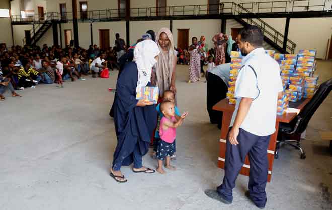  Pendatang menerima bantuan makanan di pusat perlindungan selepas                      dipindahkan dari pusat tahanan kendalian kerajaan akibat pertempuran bersenjata antara                kumpulan bermusuhan di Tripoli, Libya kelmarin. — Gambar Hani Amara/Reuters