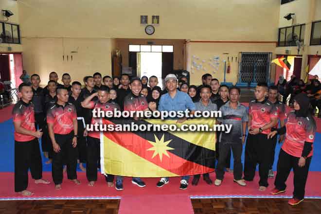  Fazzrudin (kanan) menyerahkan bendera Sarawak kepada Yusnar pada penutupan Latihan Skuad Silat Sarawak ke SUKMA XIX Fasa-IV di Kem Belia Kemunyang, Sibu kelmarin.