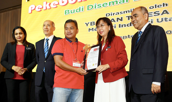 TERESA Kok menyampaikan Anugerah Industri Sawit 2018 kepada salah seorang peserta pekebun kecil sawit sempena Persidangan Kebangsaan Pekebun Kecil Sawit 2018 hari ini.