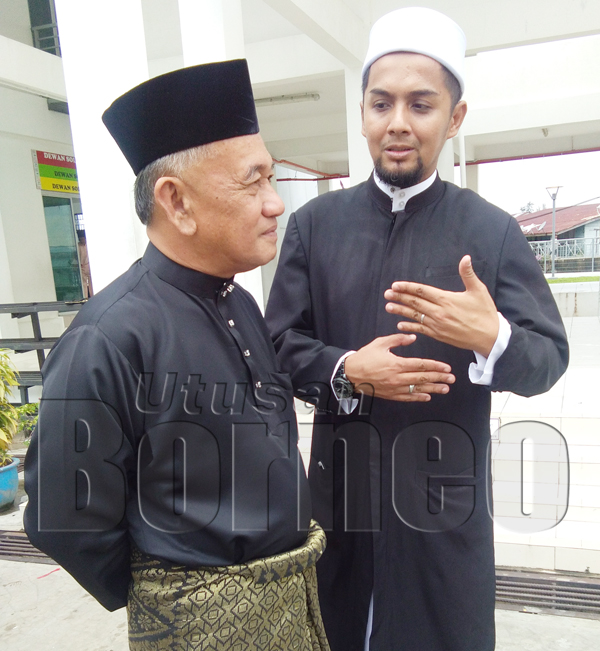RENDRA (kanan) berbincang sesuatu bersama Awang Ahmad Sah Datuk Sahari, Pengerusi Koperasi Kemajuan Perikanan dan Nelayan Sabah selaku Penasihat Jawatankuasa Masjid Al-Kauthar Tg. Aru.